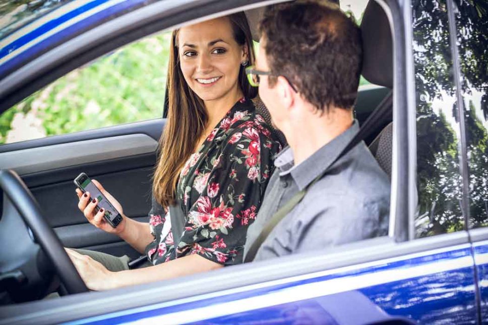 Junge Frau und junger Mann sitzen nebeneinander im Auto